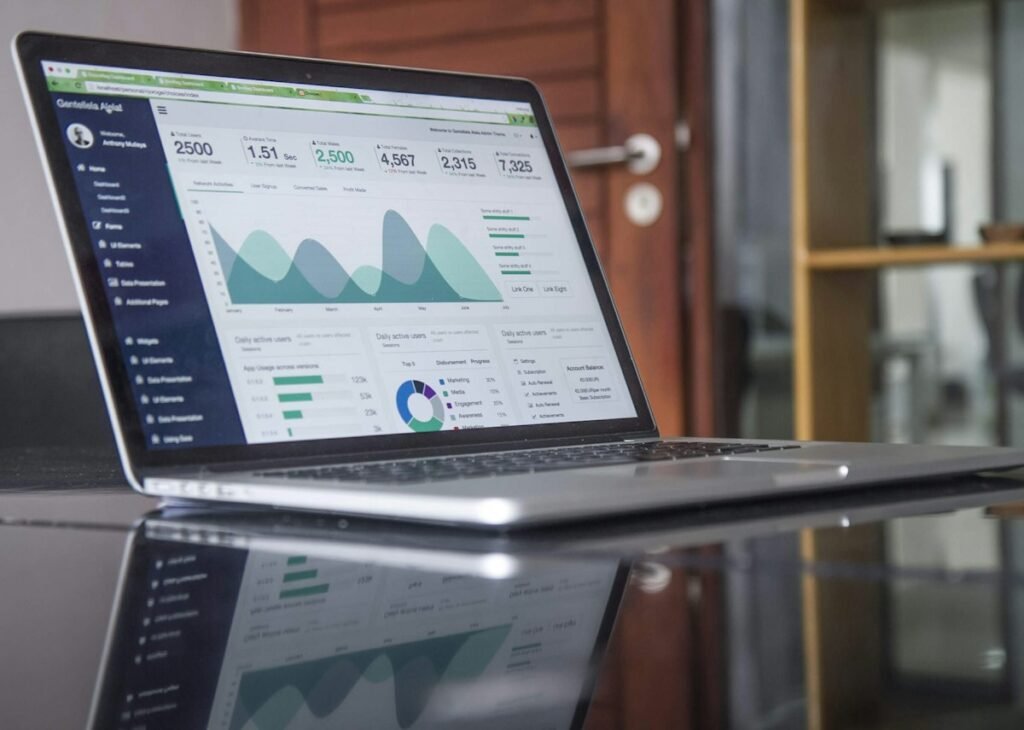 Laptop on a glass table showing an analytics dashboard
