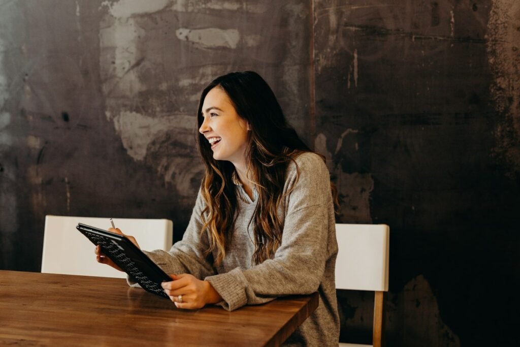 Small business owner smiling while reviewing figures on a tablet