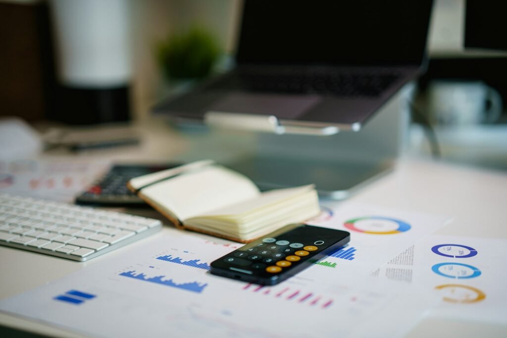 Modern desk with financial charts, calculator, and laptop