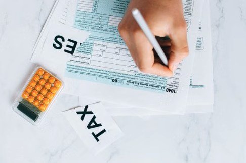 Hand filling out a tax return form